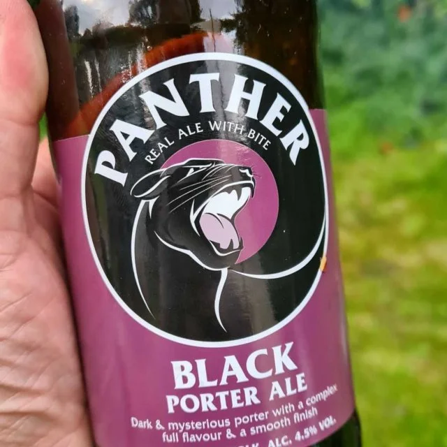 person holding a Panther Black Porter Ale bottle in their hand