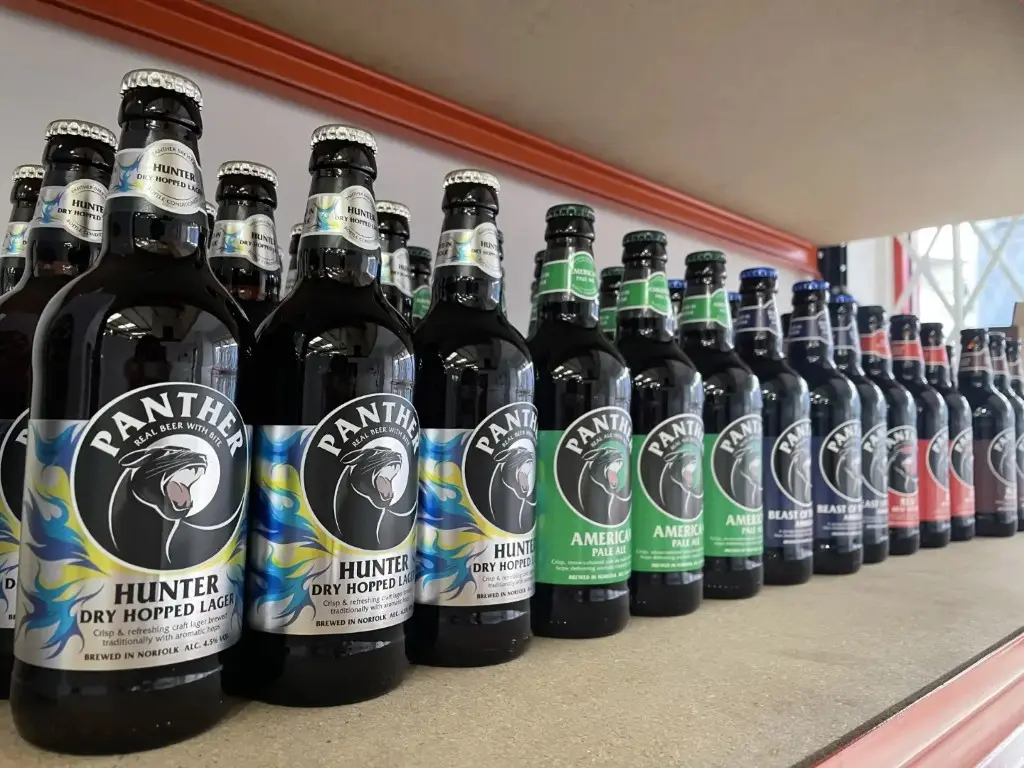 Bottles of panther beer, in a row, on a shelf