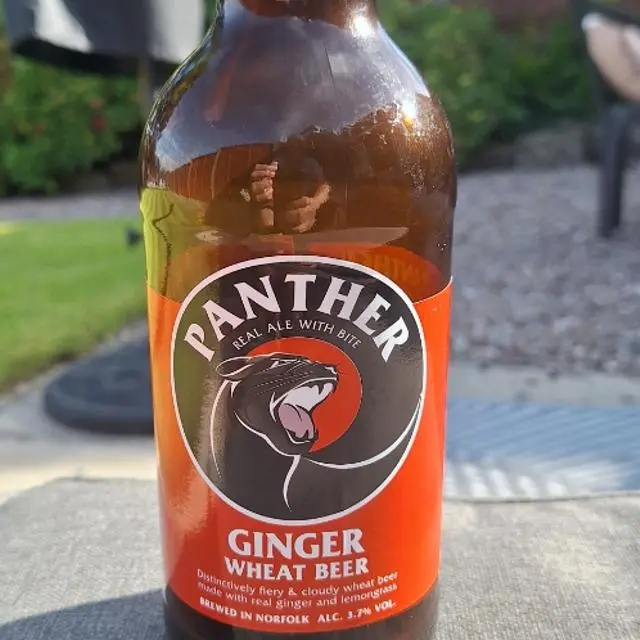 Photography showing a Panther Brewery bottle in a garden